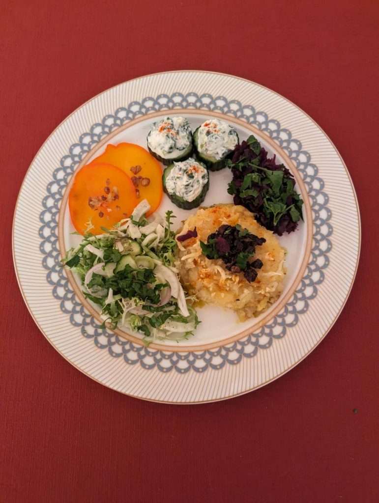 Vorspeisenteller mit Kartoffelgratin, gefüllten Gurkenröllchen, Fenchelsalat und Rotkraut