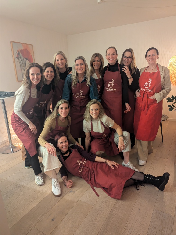 Große Gruppe von Kochkurs-Teilnehmerinnen in Fery-Licious-Schürzen beim Gruppenfoto