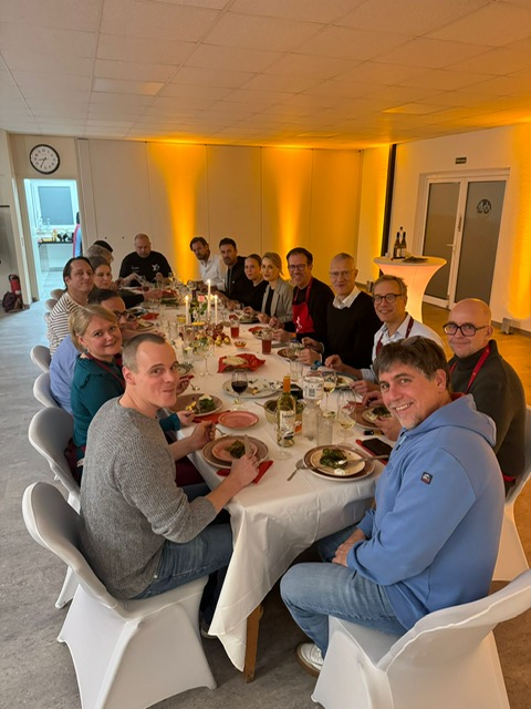 Kochkurs-Teilnehmer beim gemeinsamen Dinner an einer festlich gedeckten Tafel
